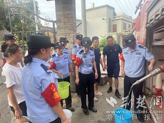 民輔警跟隨消防水車作業(yè)，通過(guò)肩挑手提的方式將清水送入行動(dòng)不便的老年、殘障村民的家中（通訊員 李麗君 攝） (3).jpg.jpg